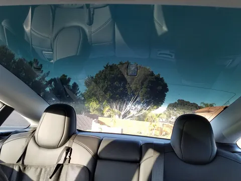 Inside a Tesla Model 3 looking back: the whole rear glass tinted evenly in one piece, from the roof section down to the trunk