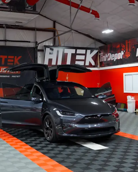 Gray Tesla Model X with its falcon-wing doors open after ceramic window tint