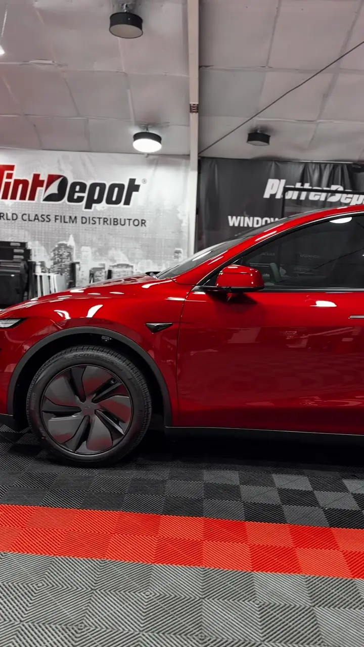 Red 2025 Tesla Model Y with ceramic window tint in the Texas Tinted shop in Houston